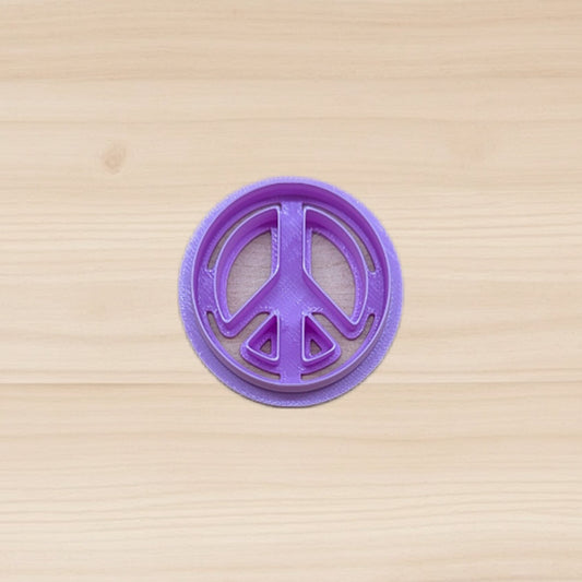Purple peace sign cookie cutter on a wooden surface
