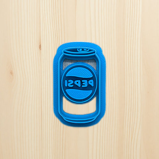 Plastic blue cookie cutter shaped like a Pepsi soda can on a wooden surface