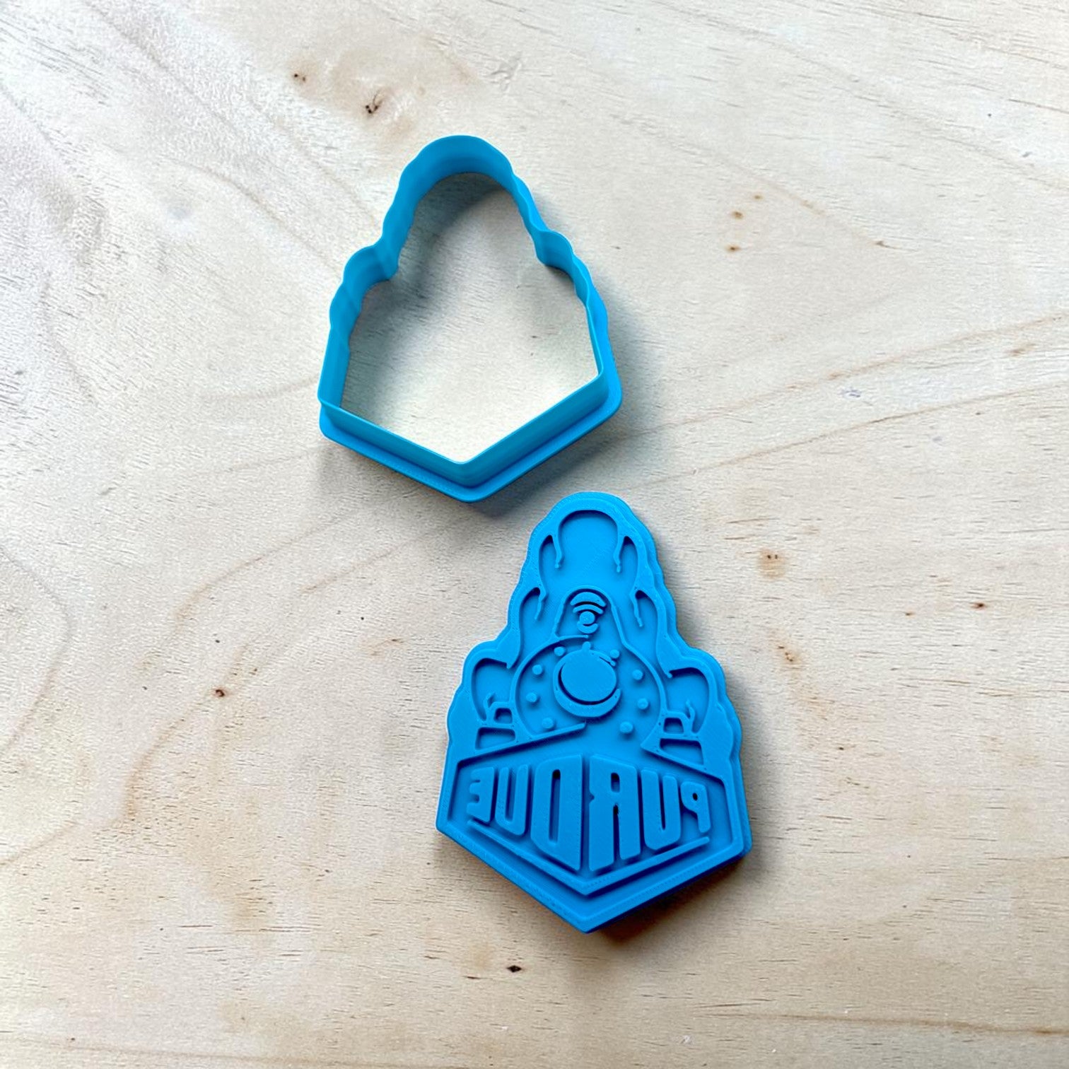 blue Purdue Boilermakers inspired train cookie cutter and stamp set for cookies fondant and clay crafts on light wood background