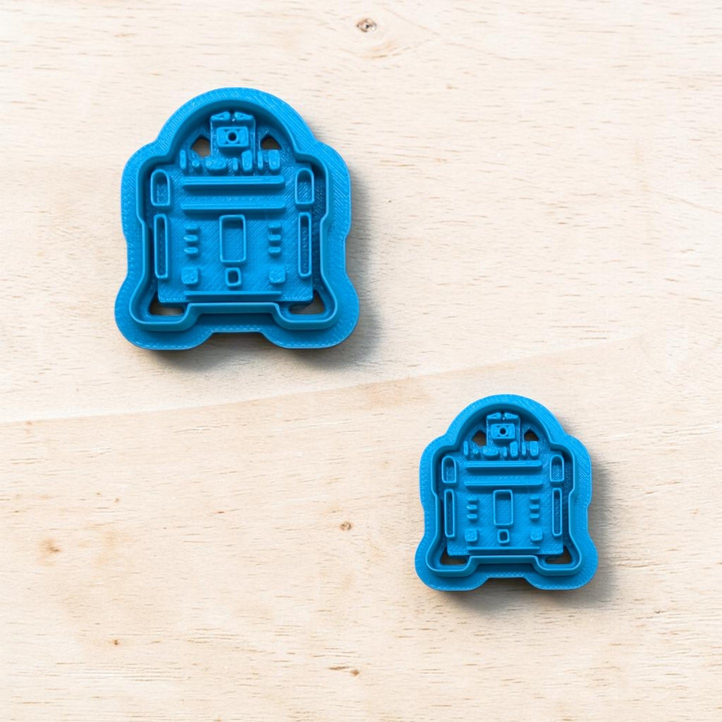 plastic R2-D2 cookie cutters on a light color wood surface