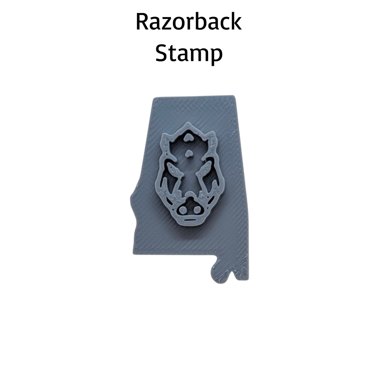 A gray Razorback Stamp mold shown on a white background with the text 'Razorback Stamp' above it. The stamp features a detailed wild boar head design.