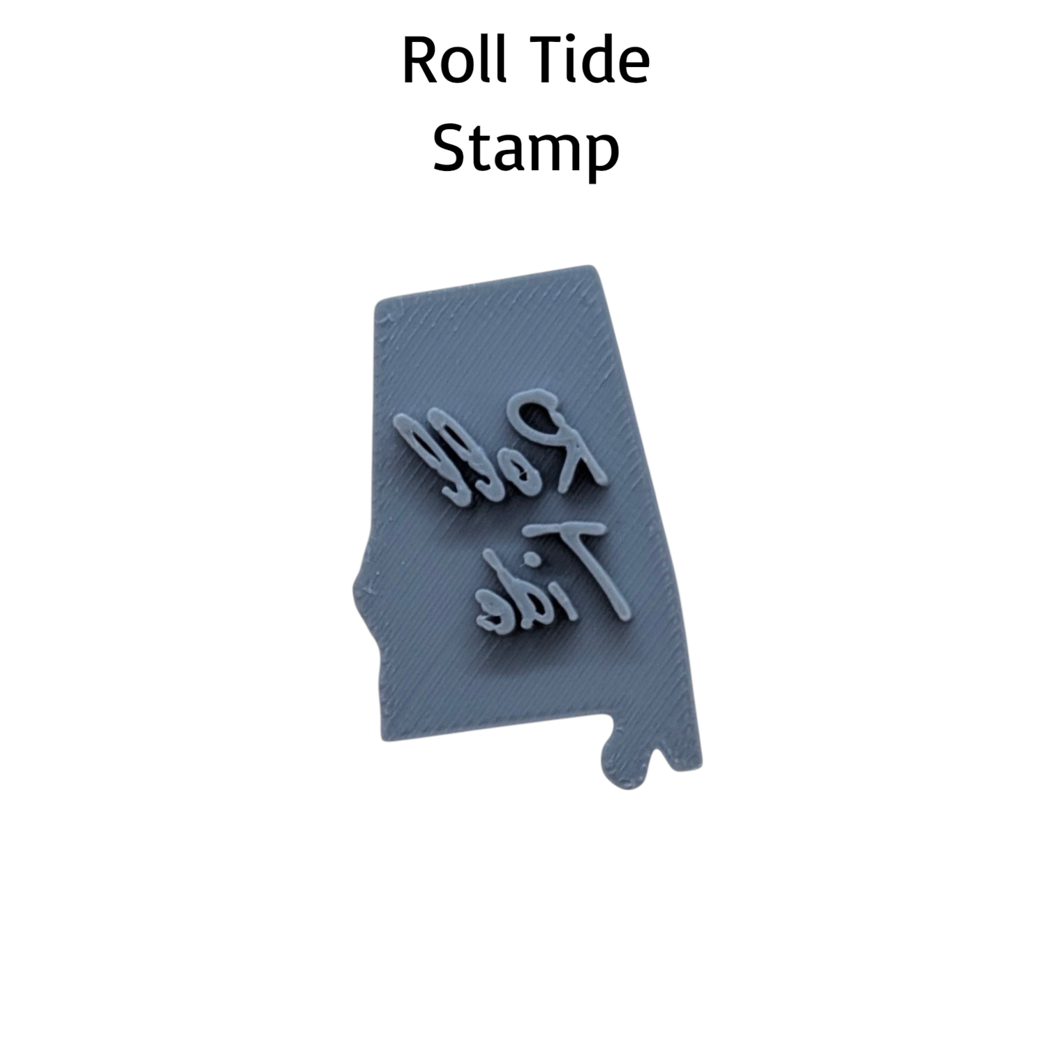 A gray 3D-printed stamp shaped like the state of Alabama, featuring the words 'Roll Tide' in raised script. The text 'Roll Tide Stamp' is written in black at the top of the image, set against a plain white background.