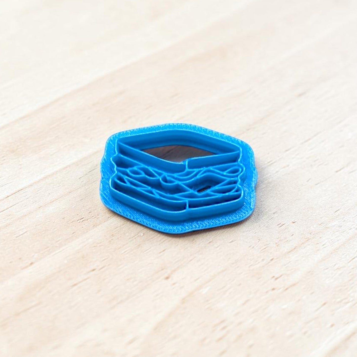 Blue 3D-printed sandwich-shaped cookie cutter on a light wooden surface