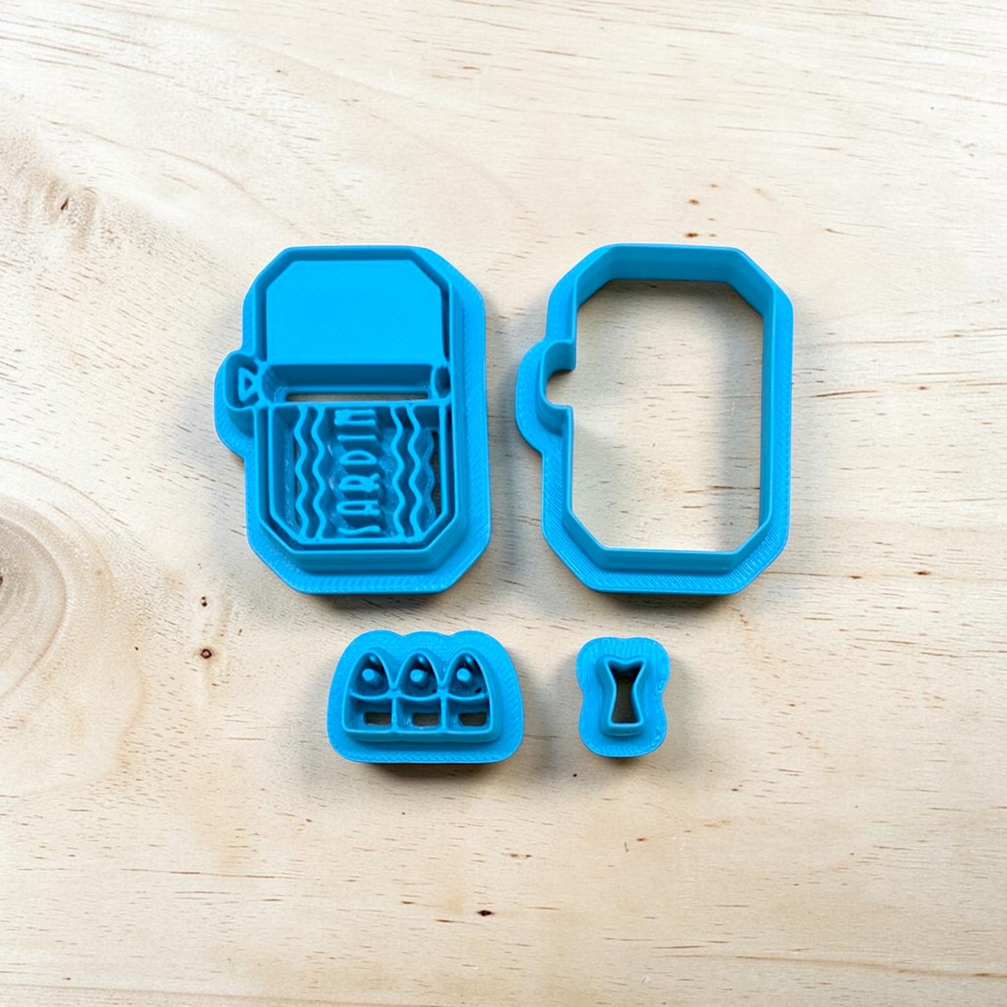 Set of blue Sardines in a can cookie cutter set on a wooden surface