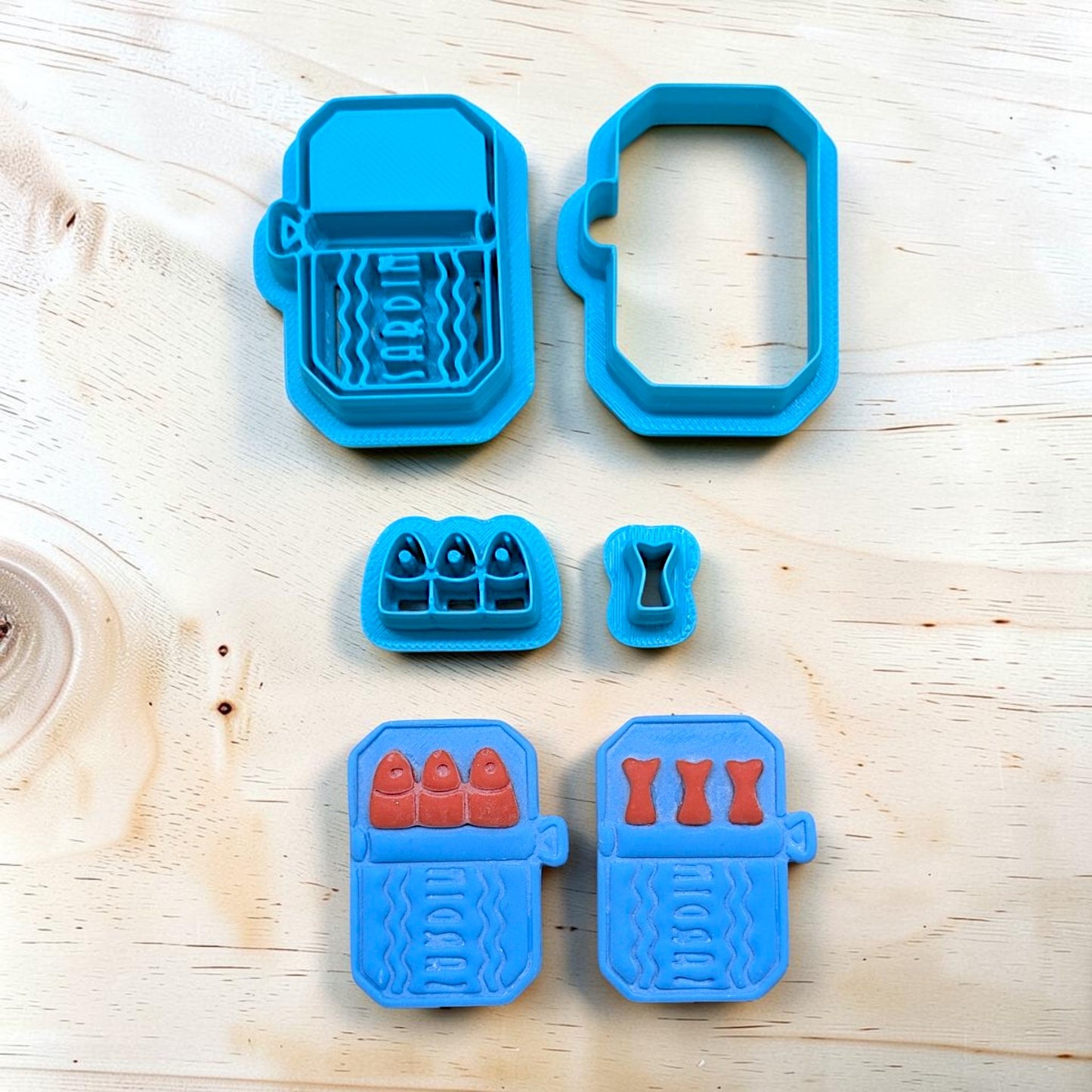 Set of blue cookie cutters with various shapes on a wooden surface