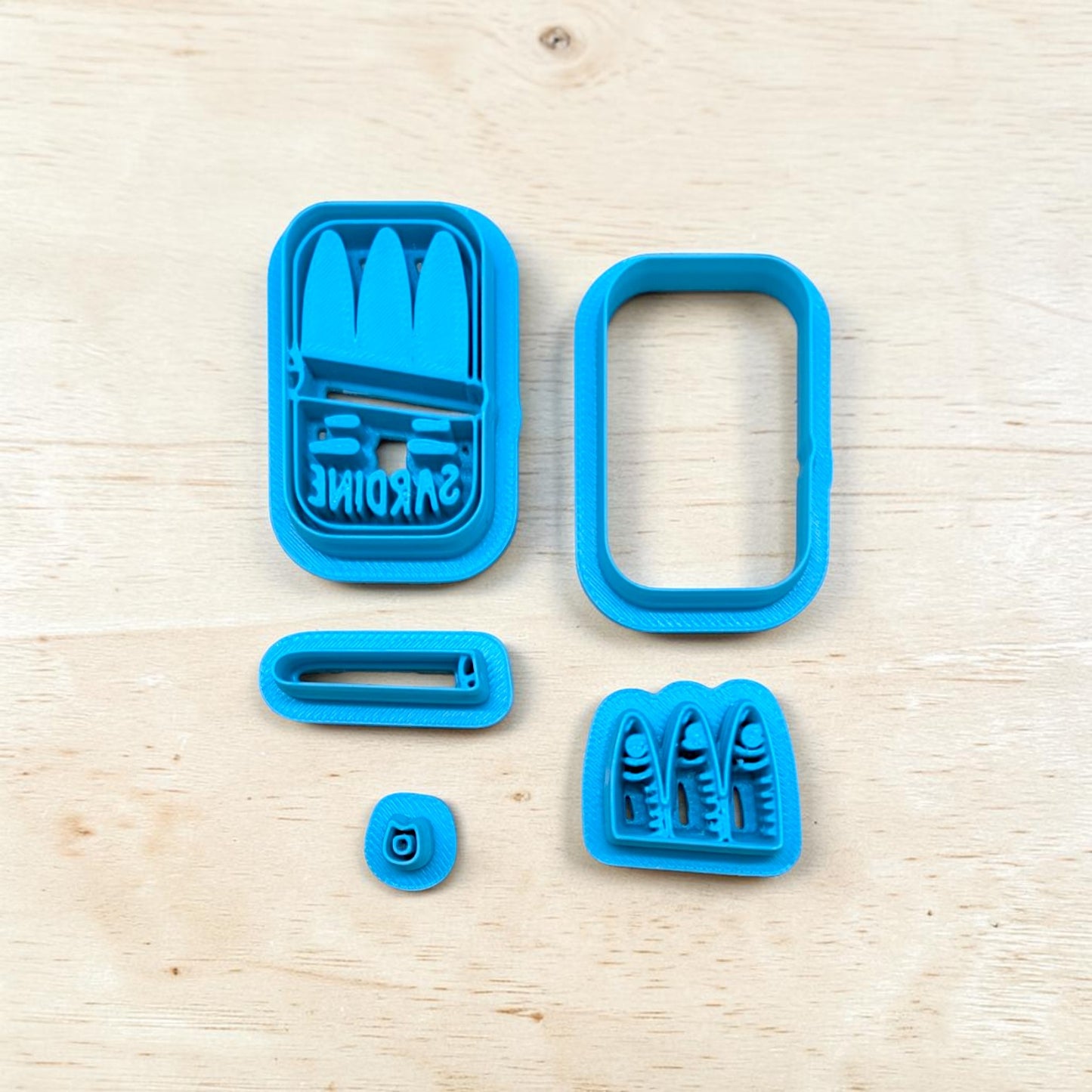 Set of blue cookie cutters on a light wood surface