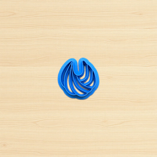 Blue cookie cutter shaped like a shell on a wooden surface