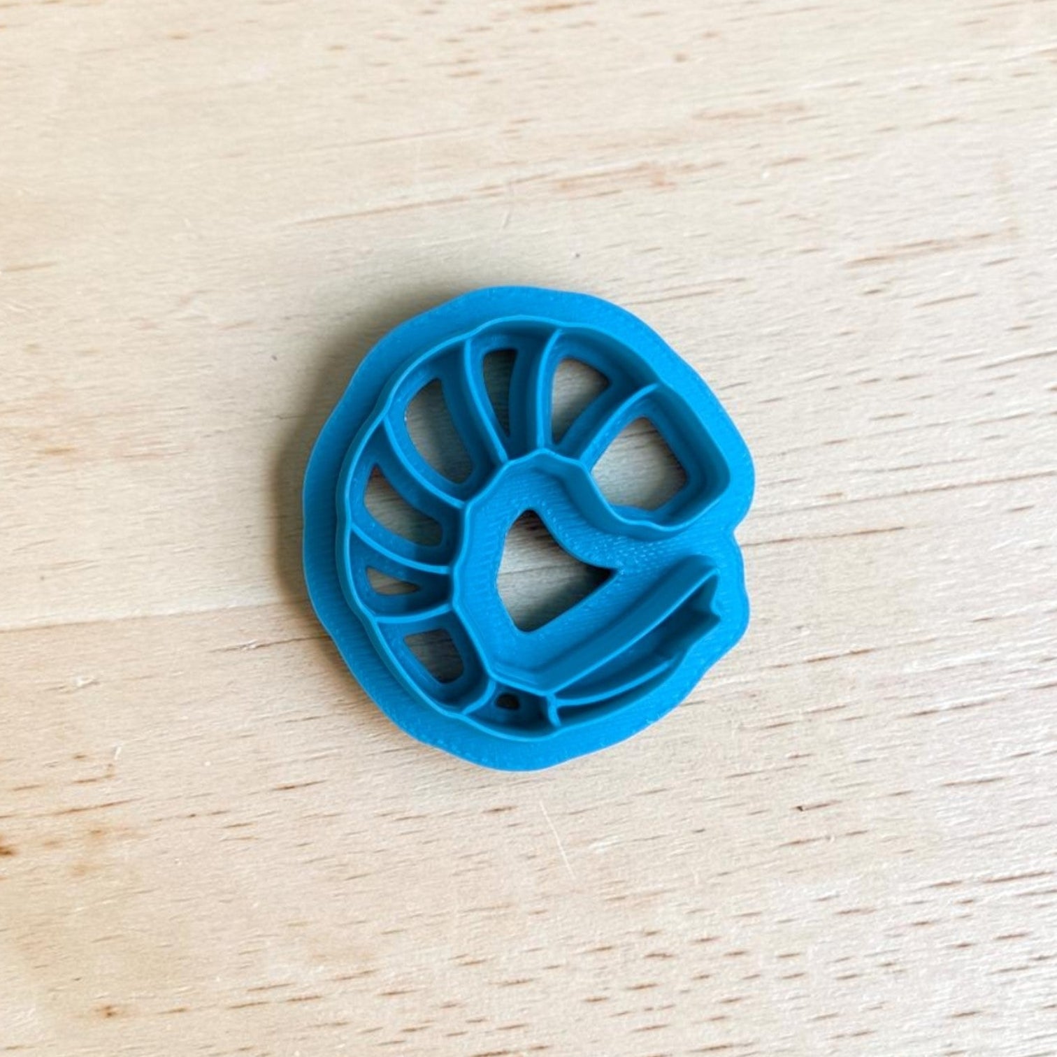 Blue plastic shrimp-shaped on a wooden surface