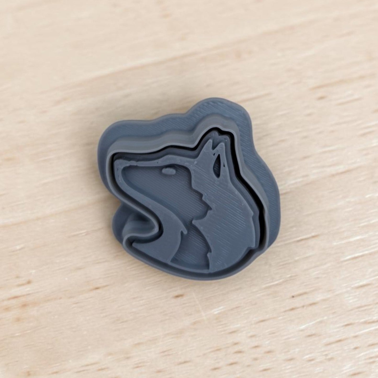 3D printed Siberian Husky head cookie cutter and stamp set in gray plastic on wooden surface — perfect for cookies, fondant, pottery, and polymer clay crafts.