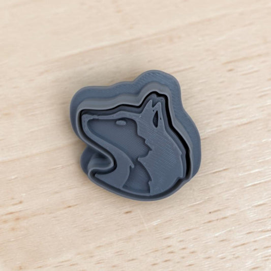 3D printed Siberian Husky head cookie cutter and stamp set in gray plastic on wooden surface — perfect for cookies, fondant, pottery, and polymer clay crafts.