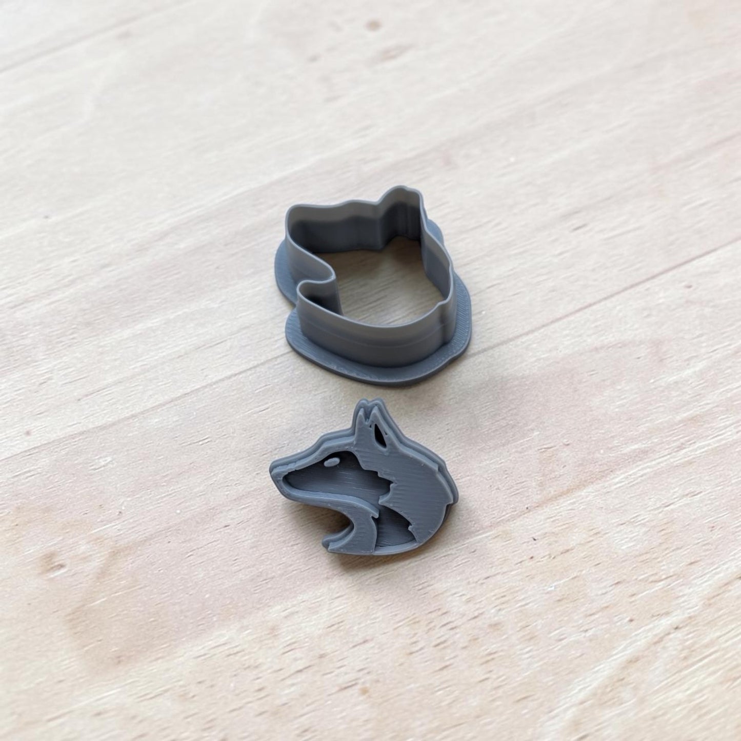 Gray Siberian Husky cookie cutter and matching stamp piece displayed on light wood — detailed 3D printed design ideal for polymer clay, fondant, and pottery.