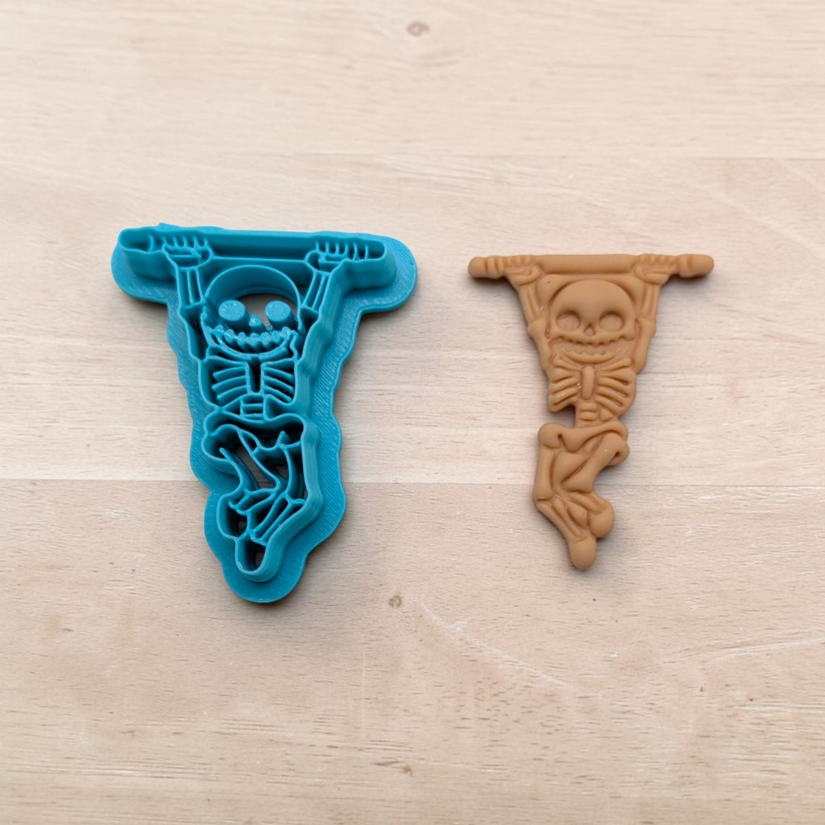 Skeleton Acrobat cookie cutter and matching clay impression – blue cutter with brown skeleton design for polymer clay or fondant crafts