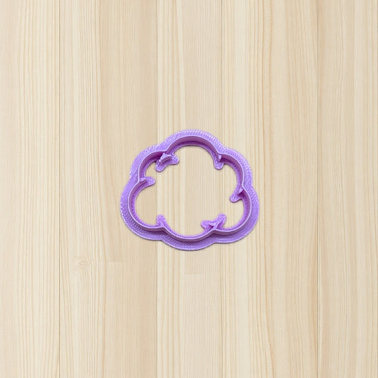 purple plastic smoke puff cloud cookie cutter on a wooden surface
