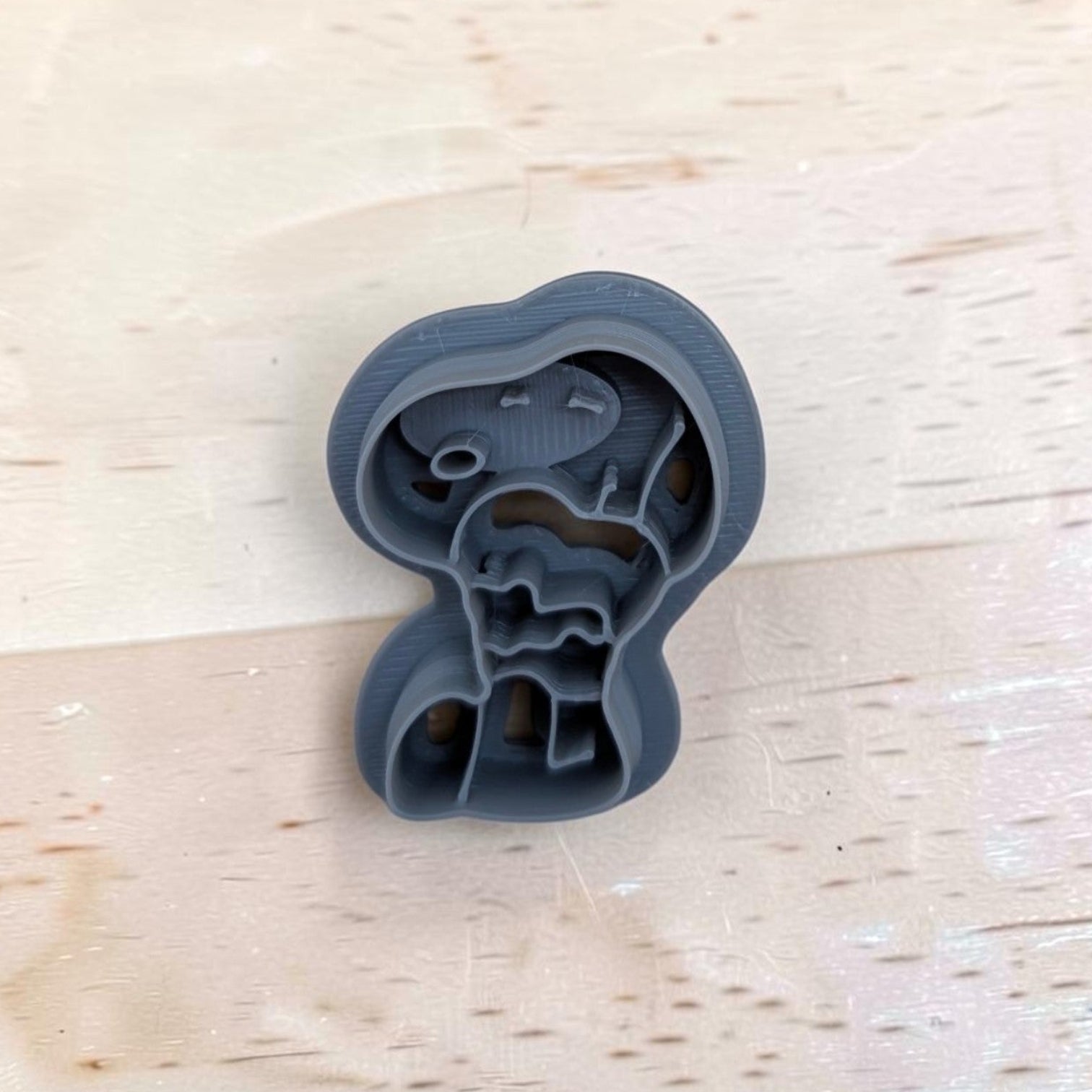 Gray 3D‑printed Snoopy hugging a heart cookie cutter on light wood background — multi‑medium tool for cookies, clay, fondant, and pottery crafts.
