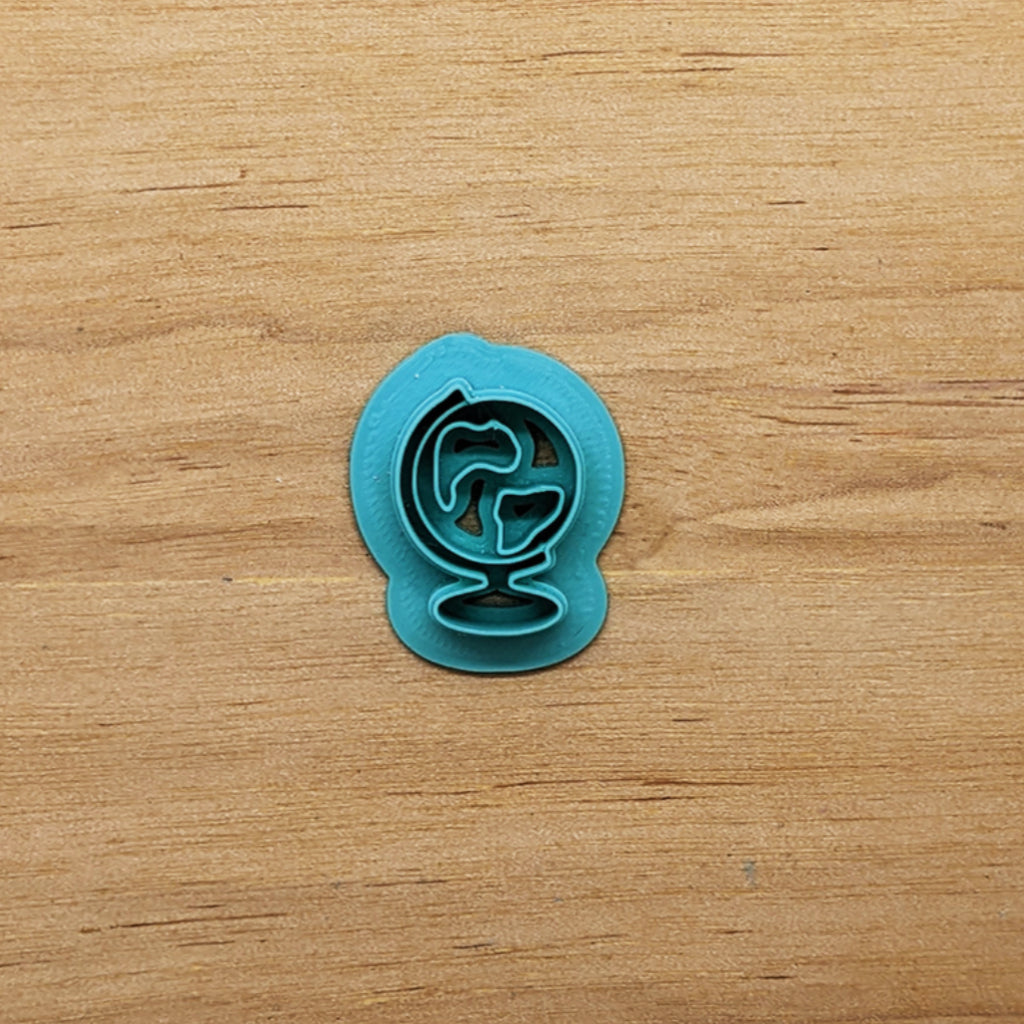 Spinning globe cookie cutter on wood surface