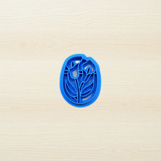 Blue cookie cutter with floral design on a beige surface