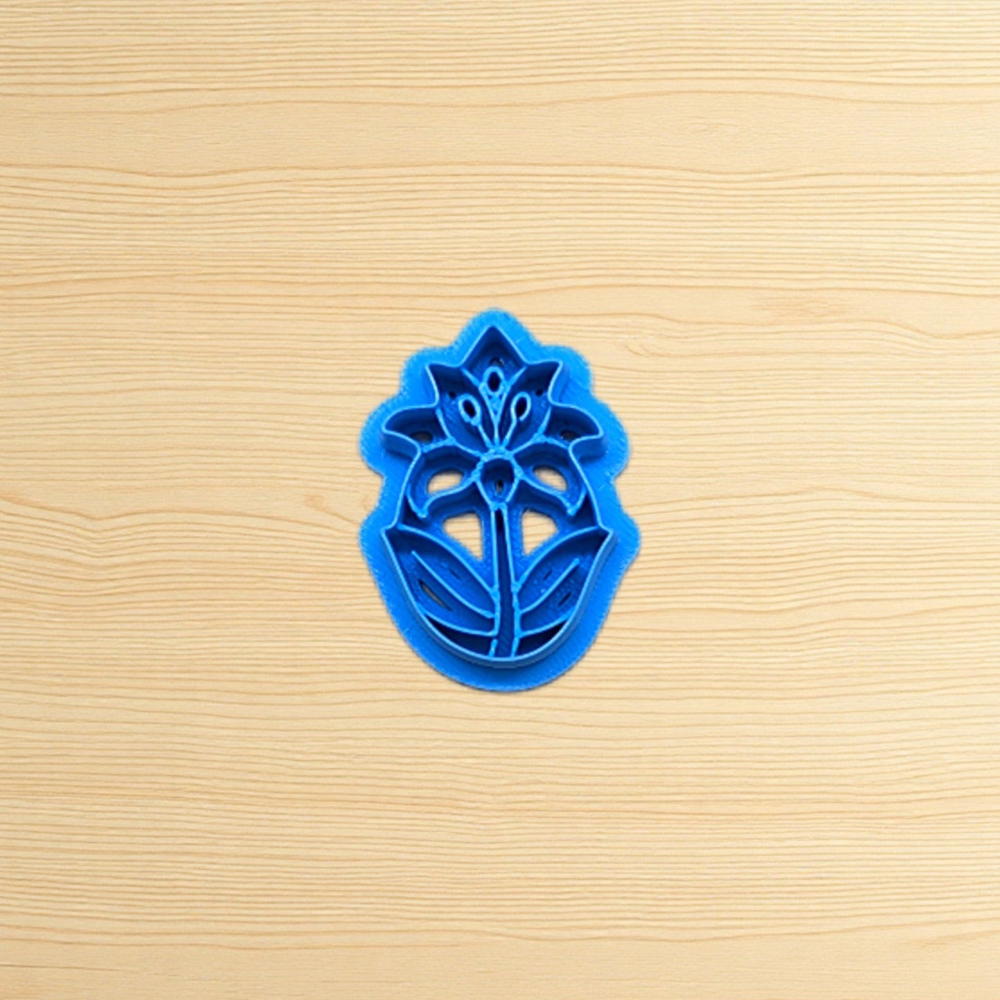 Blue floral cookie cutter on a wooden surface