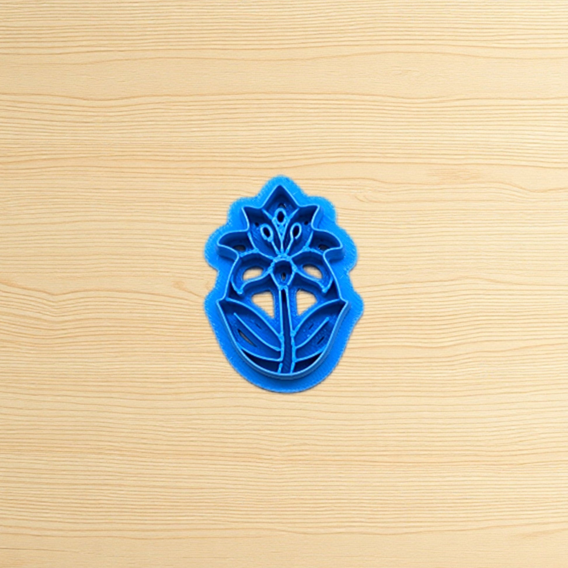 Blue floral cookie cutter on a wooden surface