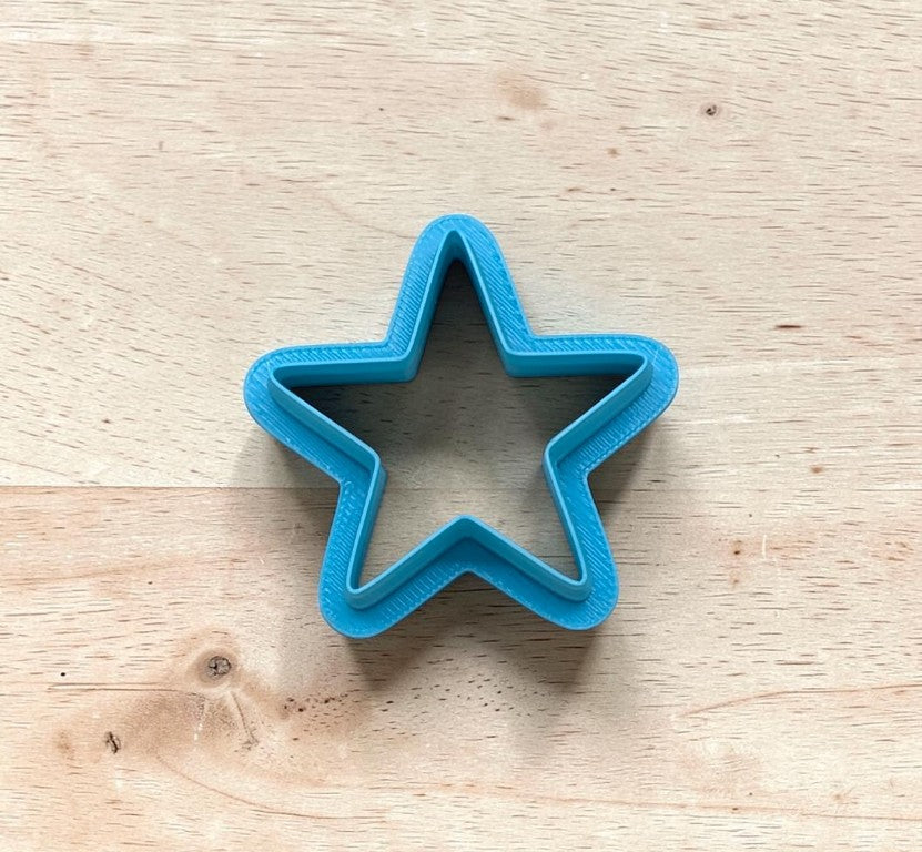Blue star-shaped cookie cutter on a wooden surface