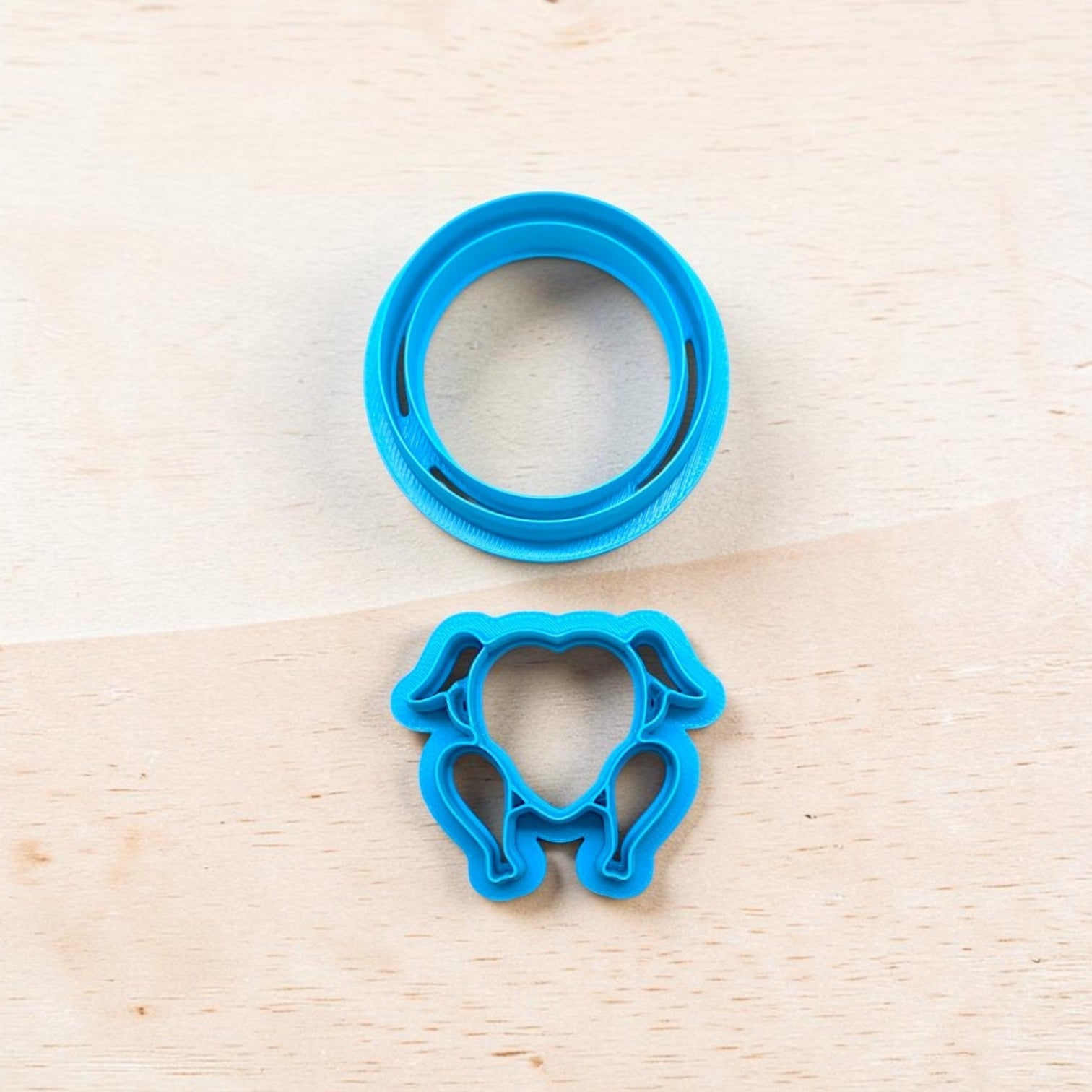 A bright blue plastic turkey shape cookie cutter and matching platter set on a light wood grain surface.