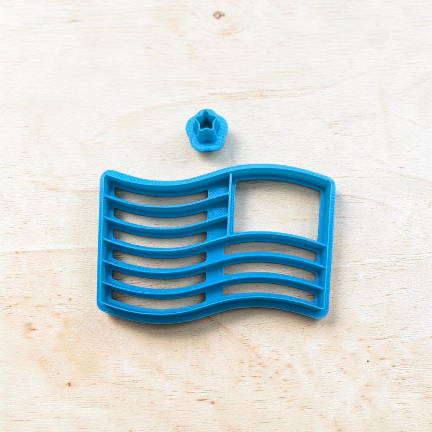 Blue plastic tool with a star-shaped component on a light wooden surface