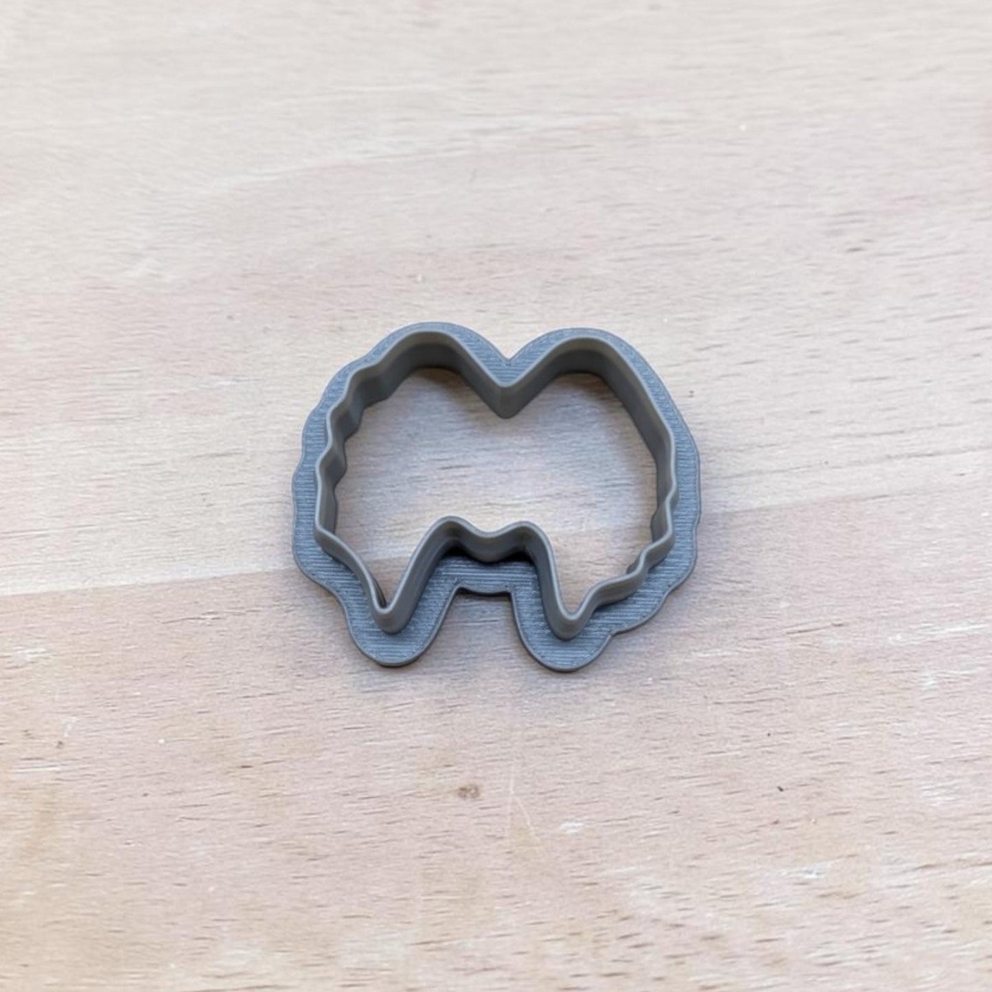 Gray 3D‑printed Winifred Sister hair cookie cutter on wooden background, food‑safe polymer clay and fondant tool.