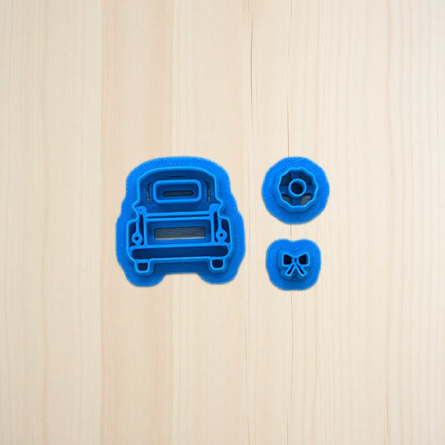 Blue cookie cutters shaped like a truck on a wooden surface