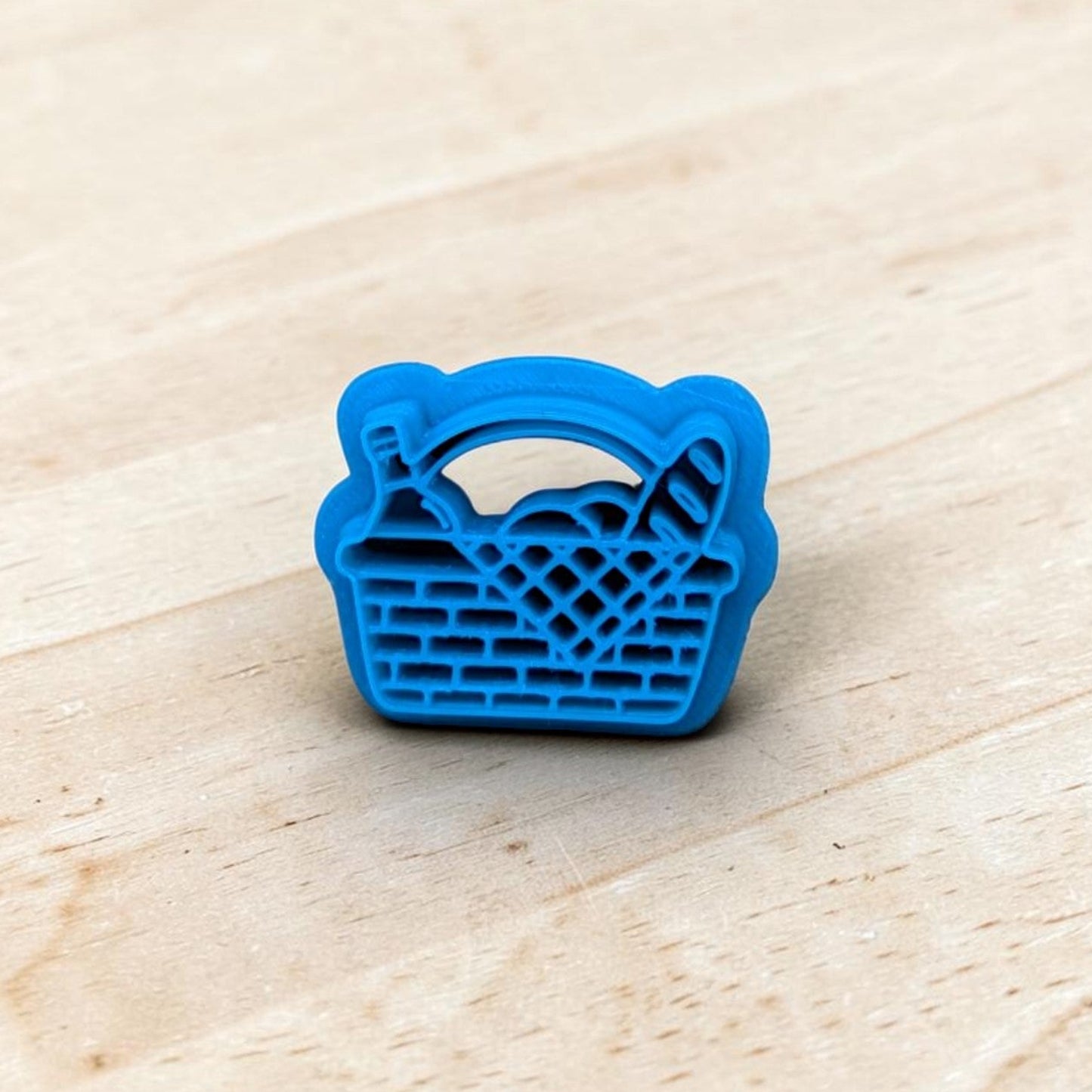 Blue basket-shaped cookie cutter on a wooden surface